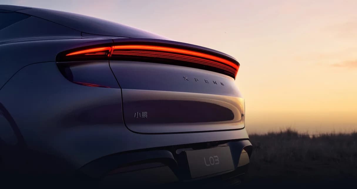Xpeng L03 rear three-quarter view at sunset, badge and plate visible